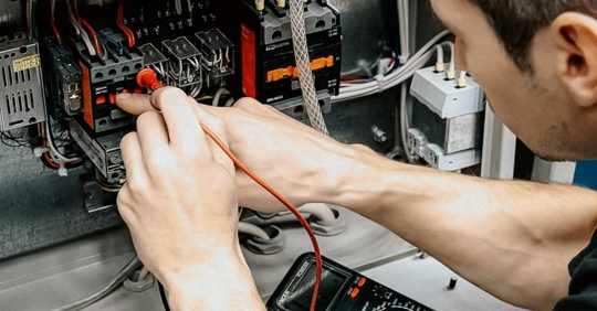 Electrician Diagnosing Electrical Panel with Multimeter