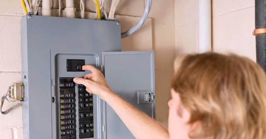 Man checking tripped breaker